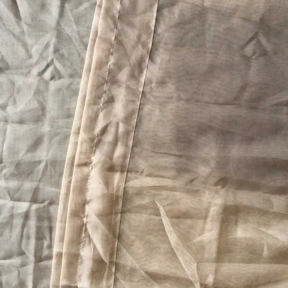 Two sheer terra-cotta rod pocket curtain panels